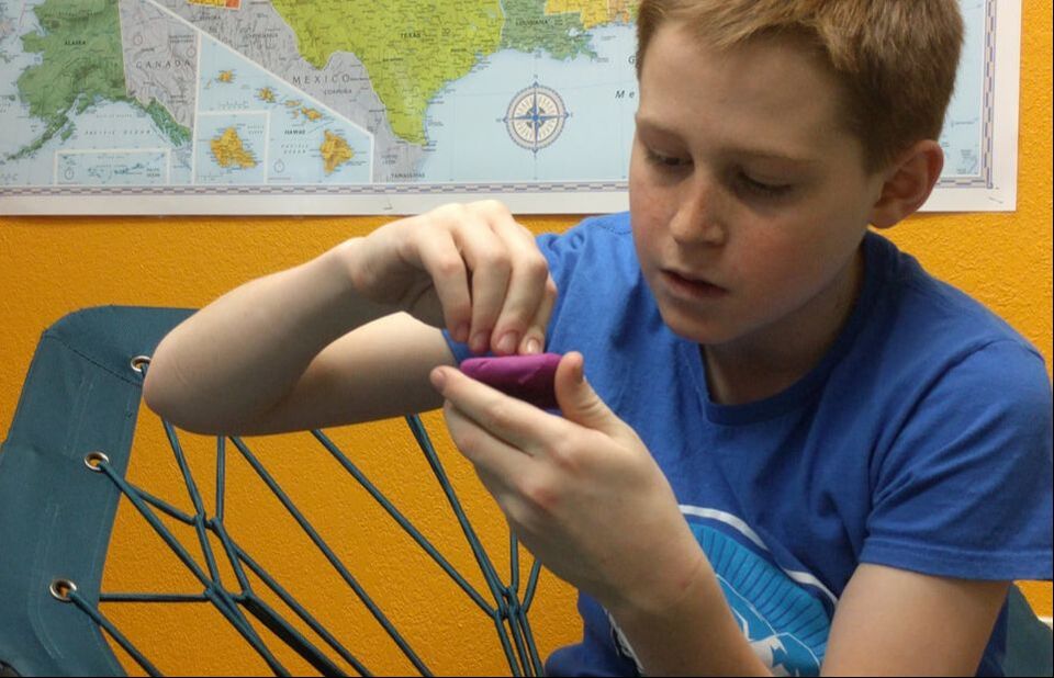 A student concentrating on a hands-on learning activity